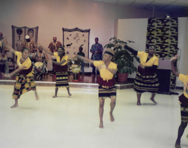 Circa 1997. Entertainment by dancers from the Youth Group Dance Team. The colorful custom outfits fit the occasion and celebration well.