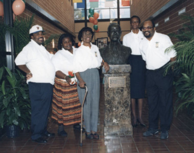 Circa 1997. Callahan’s community patrons posing with history at the bust of L. C. Jones, first principal of the “FAME” Jones High School. The bust is in the vestibule of the J. B. Callahan Center. Callahan’s community patrons posing with history at the bust of L. C. Jones